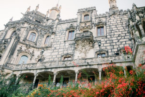 Grey stone building with red flowers Palacio in Sintra, Portugal
