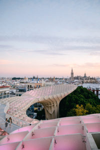 pink with a tint of orange in the Seville, Spain skyline. the parosal structure 