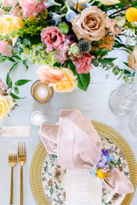 Table decoration of bright and colorful flowers with mauve and blue plate setting at Lairmont Manor in Bellingham, WA