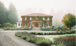 Monet Vineyards building covered by ivvy surrounding with evergreen trees setting in the garden like venuesis best venue for wedding and engagement shoot